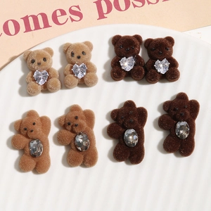 Detail of DIY flocked brown bear charms with inlaid crystal hearts on a ceramic tray