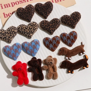 Detailed view of flocked leopard heart, bear and dachshund charms for DIY crafts