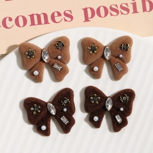 Detail of flocking bow accessories with rhinestones and pearls on a ceramic tray