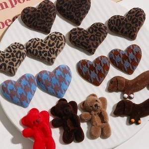 Detailed macro of flocked leopard heart, teddy bear, and dachshund dog DIY accessories
