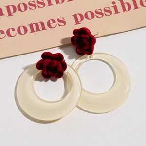 Dettaglio degli orecchini a rosa di velluto rosso con cerchio in acrilico bianco e texture