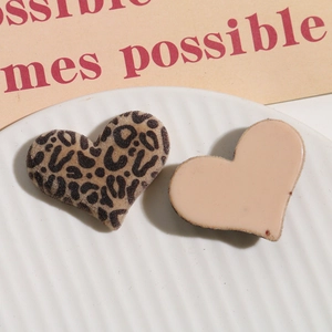 Detailed view of leopard print flocked heart and plain beige resin charms for DIY hair crafts