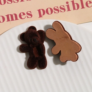 Close-up of brown flocked bear and rabbit charms for DIY hair accessories and phone cases