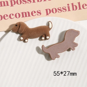 Brown flocked dachshund resin patch for DIY accessories shown on a white ceramic plate