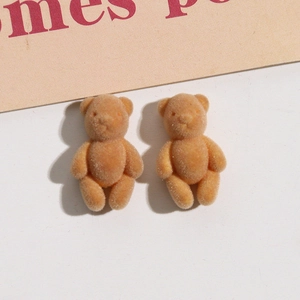 Close-up of cute beige flocked bear charms with soft velvet texture for DIY jewelry making