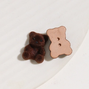 Detailweergave van pluche beerbedeltjes met tweeknoops achterkant voor DIY sieraden