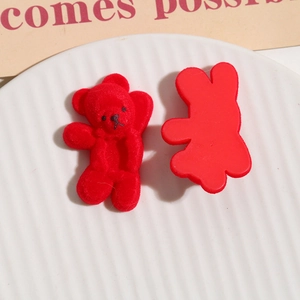 Macro view of red flocked bear charms for DIY hair accessories showing texture and back