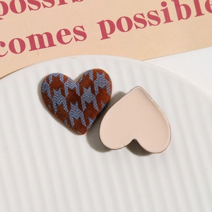 Close-up of heart-shaped accessories featuring brown flocking and blue houndstooth pattern