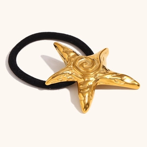 Detail of 18K gold-plated starfish pendant with hammered texture on black elastic hair tie
