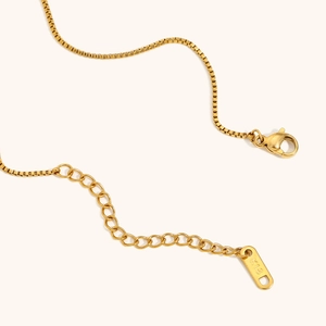 Detailed macro view of 18K gold plated lobster clasp and adjustable extension chain