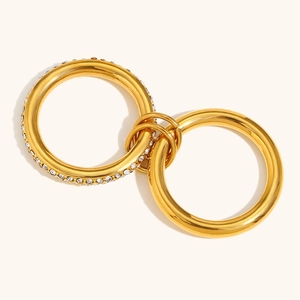 Detail of interlocking 18K gold plated rings featuring pavé diamonds and polished bands