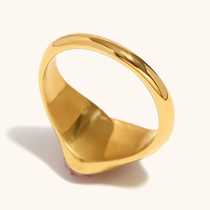 Close-up of a wide polished 18K gold plated stainless steel ring with a smooth thick band