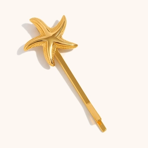 Starfish gold hair pin with textured detail and 18K gold plating on a beige background