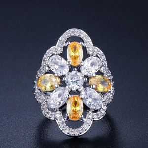 Macro shot of silver ring with yellow gemstones and floral micro-pave setting