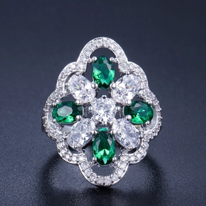 Close-up of floral cocktail ring with emerald and white cubic zirconia stones