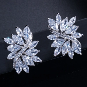 Macro detail of silver floral earrings with marquise-cut zircon stones on black stand