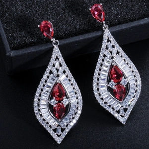 Detalle de pendientes colgantes con circonita roja y pavé de cristales en plata de ley
