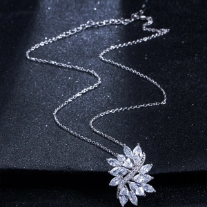 Close-up of marquise-cut zircon flower pendant necklace on black glitter background
