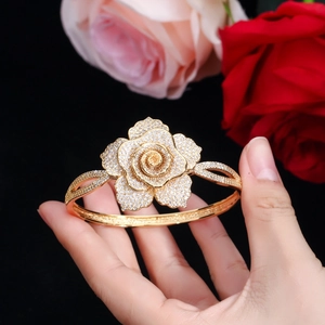 Macro shot of a gold rose open cuff bracelet with sparkling zircon pavé flower petals