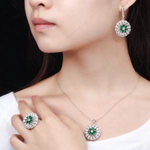 Exquisite silver-toned flower jewelry set with emerald green stones on model