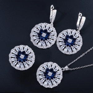 Macro view of flower-shaped jewelry set featuring deep blue pear zircon and silver plating