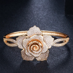 Macro detail of rose flower open bangle with shimmering pavé zircon stones in warm gold