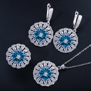Flat lay of flower zircon jewelry set with blue and white stones on black background