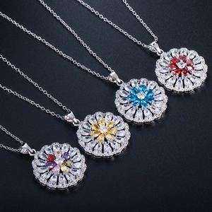 Detail of four colorful flower pendant necklaces with zircon crystals on black background
