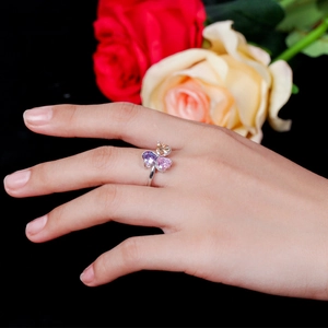 Detailed view of silver clover ring with three heart-shaped gemstones worn on a finger