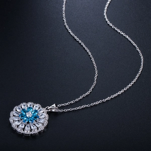 Detail of floral pendant with marquise-cut blue and clear stones on silver chain