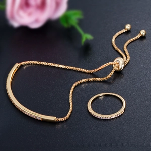 Detailansicht von Gold-Armband und Ring Set mit Zirkonia auf schwarzem Hintergrund