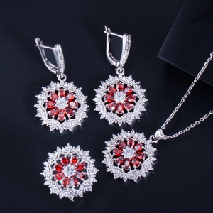 Nahaufnahme eines S925 Sterling Silber Schmucksets mit roten Zirkon-Blütenanhängern