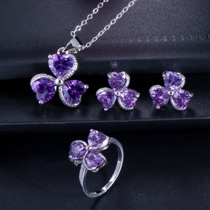 Macro shot of purple heart-shaped zircon necklace, earrings and ring set in silver finish