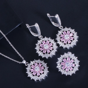 Makro-Detail von silbernem Halsketten-, Ohrring- und Ring-Set mit rosa Zirkonia-Blumen