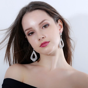 Boucles d'oreilles pendantes en argent avec zircons AAA portées par un mannequin