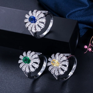 Macro detail of three flower rings with blue, green and yellow stones in a display box