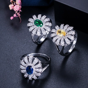 Macro detail of daisy rings with emerald, yellow, and blue stones in cubic zirconia