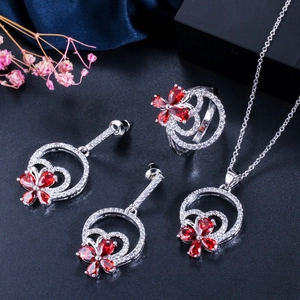 Detailansicht eines silbernen Blumenschmucksets mit roten Steinen und weißem Zirkon