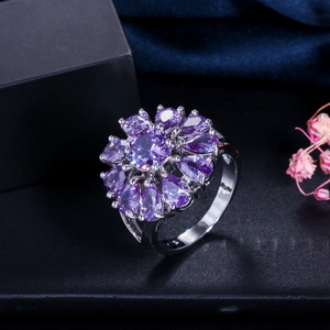 Primer plano de un anillo de flor con circón morado AAA y pétalos de gota de agua