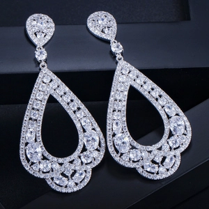 Détail macro de boucles d'oreilles pendantes en goutte avec pavage de zircons AAA étincelants