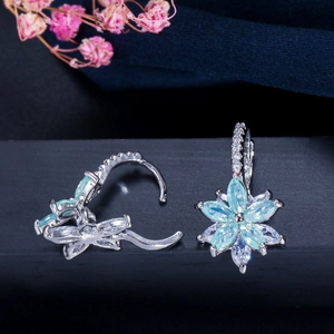 Détail de créoles fleurs en argent avec zircons marquise bleus et fermoir à charnière