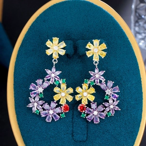 Macro detail of floral drop earrings with multicolored zircons on velvet display