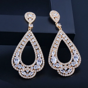 Détail macro de boucles d'oreilles pendantes en forme de goutte avec zircons AAA dorés