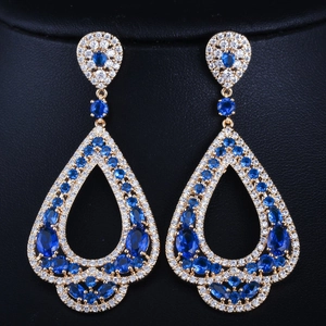 Vue détaillée des boucles d'oreilles gouttes en zircon bleu et monture dorée