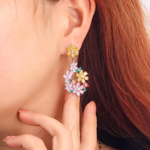 Elegant floral drop earrings with multicolored zircons on a model for a chic garden style