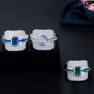 Macro-weergave van drie luxe ringen met blauwe, witte en smaragdgroene vierkante stenen