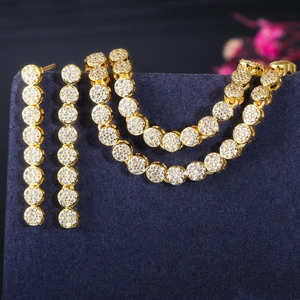 Elegant gold zircon jewelry set with necklace and drop earrings on blue velvet
