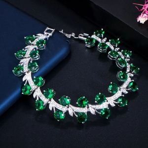 Macro-detail van zilveren armband met groene ovale edelstenen en zirkonia versiering