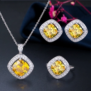 Detailed close-up of yellow cushion-cut zircon jewelry set with necklace ring and earrings
