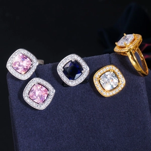 Detailed macro view of cushion-cut cubic zirconia rings in pink, blue, and white colors